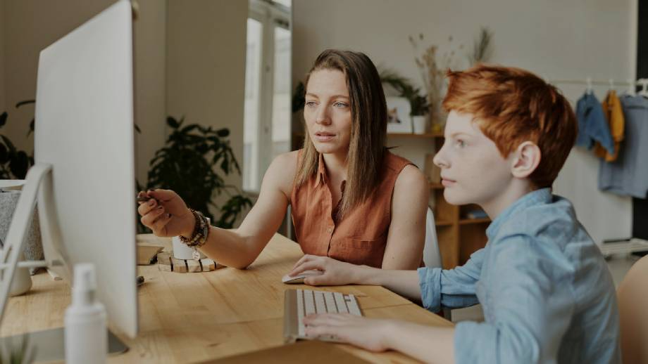 A mother educating her son about online safety via computer connected to fast internet